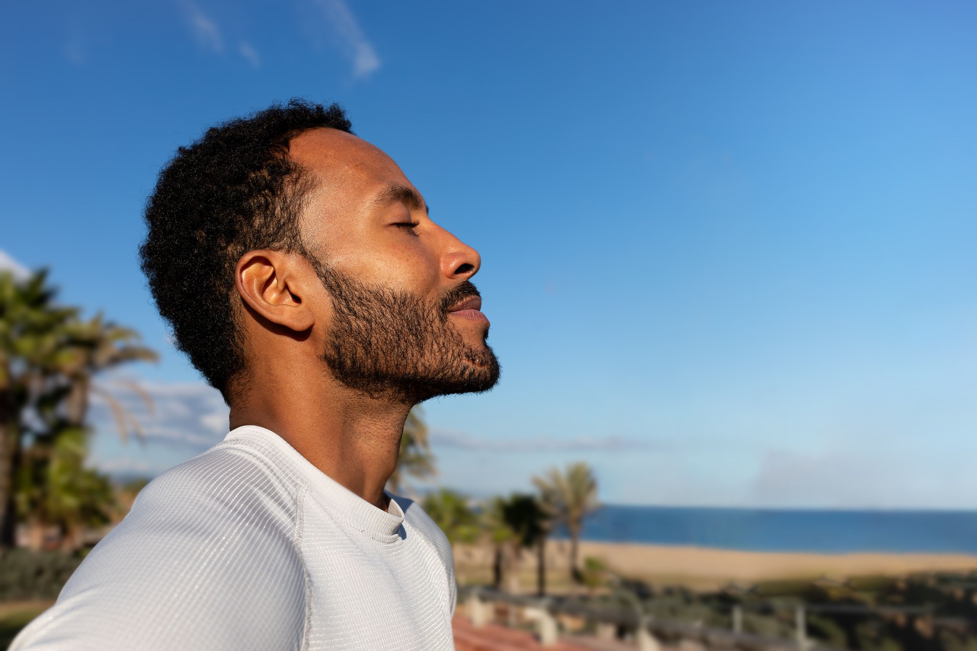 Young man breathing fresh air on a sunny day at the beach